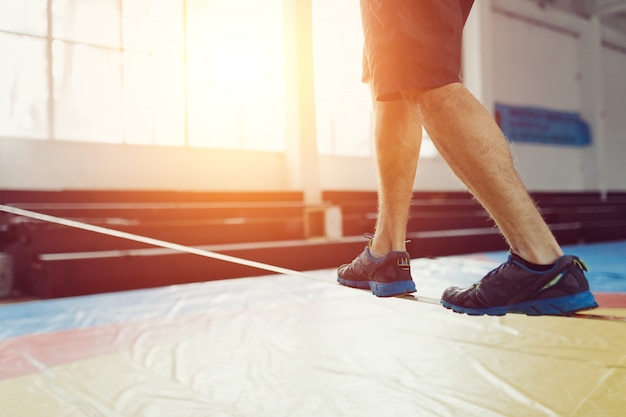 Mann Slacklining gehen und balancieren auf einem Seil, Slackline in einer Sporthalle