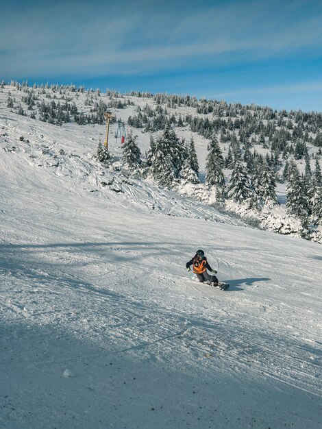 Mann Snowboarder bei Winteraktivitäten auf der Skipiste