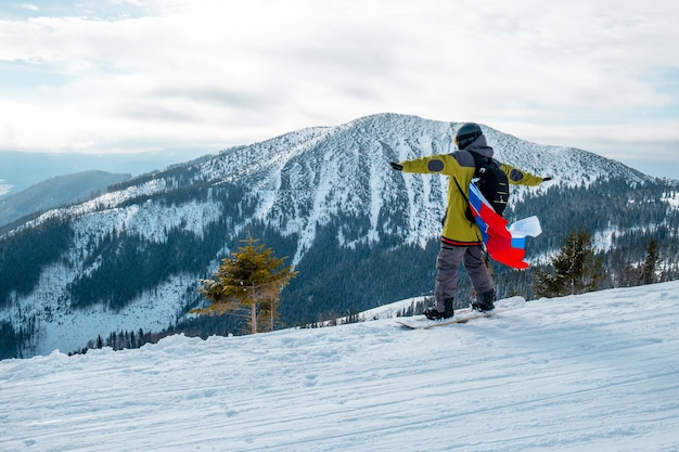 Mann Snowboarder mit slowakischer Flagge an der Piste des Skigebiets