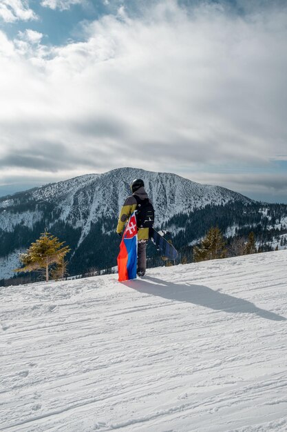 Mann Snowboarder mit slowakischer Flagge an der Piste des Skigebiets