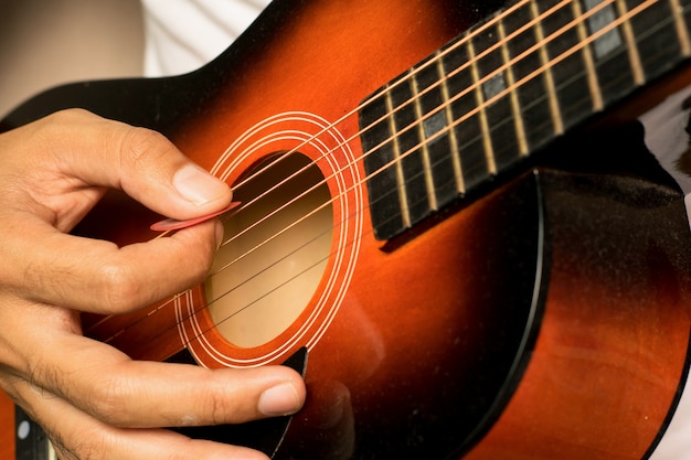 Mann spielt akustische Gitarre