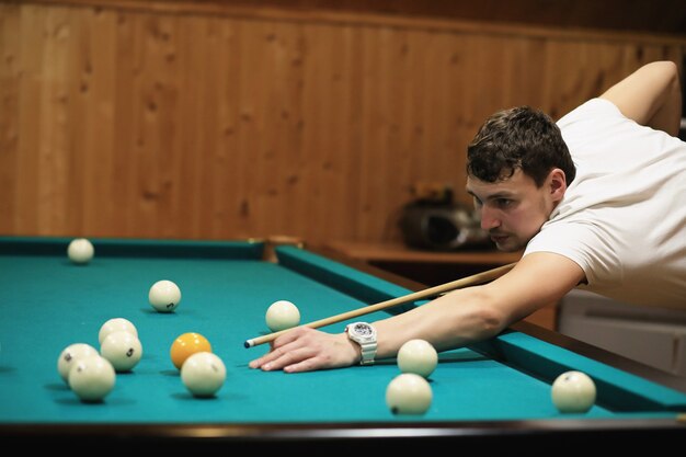 Mann spielt billard und zielt vor dem turn