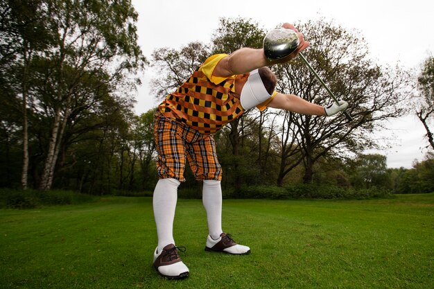 Foto mann spielt draußen auf dem feld golf