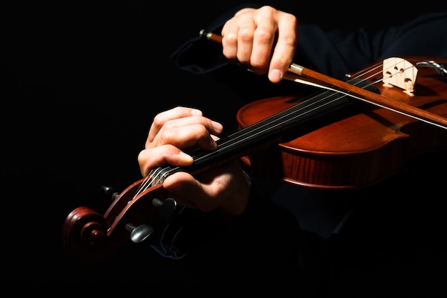 Mann spielt Geige auf schwarzem Hintergrund