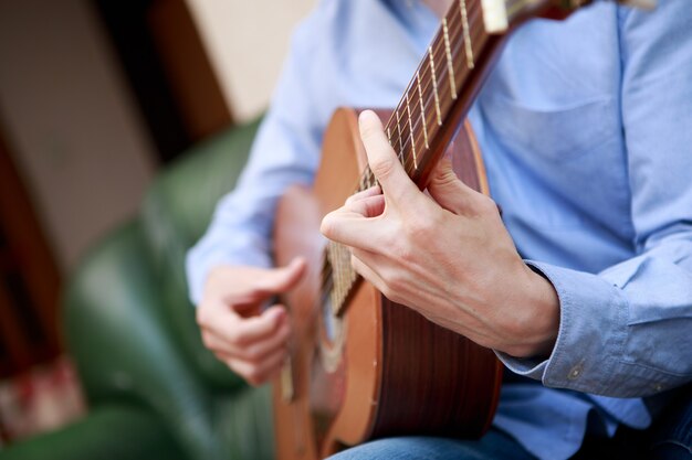 Mann spielt klassische Akustikgitarre