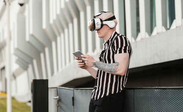 Mann spielt mit seinem Smartphone und einer Virtual-Reality-Brille