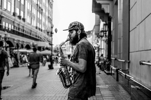 Foto mann spielt saxophon in der stadt