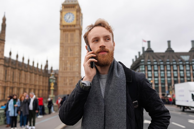 Mann spricht auf einem Mobiltelefon, während er in der Nähe von Big Ben in London steht
