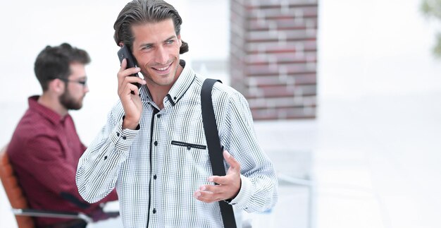 Mann spricht im Büro über Smartphone