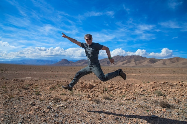 Mann springt vor Freude auf den Berg