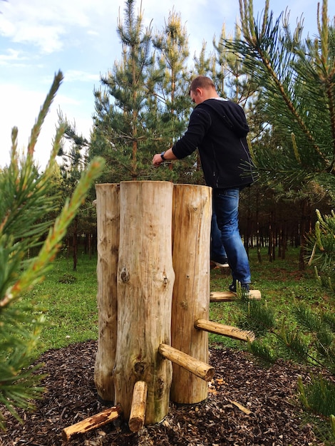 Foto mann steht am holz im park