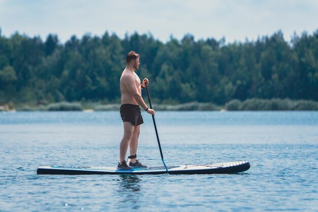 Mann steht auf dem Supboard mitten im See