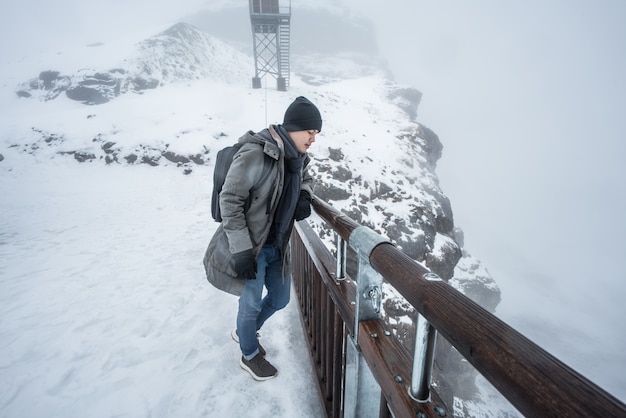 Mann steht auf einer Schneeklippe in der Schweiz