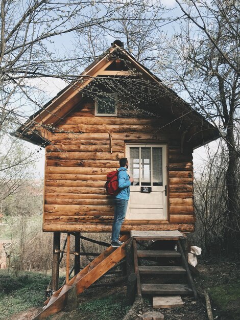 Foto mann steht vor dem baumhaus