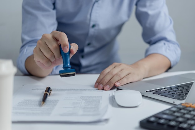 Mann stempelt die Genehmigung von Arbeitsfinanzierungs-Banking- oder Investment-Marketing-Dokumenten auf dem Schreibtisch