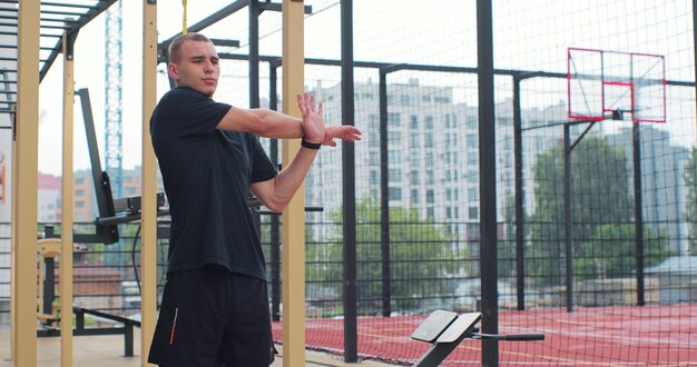 Mann streckt Arm-Schulter-Muskel flexible Übung Fitness-Training auf Sportplatz Körperliches Training Gesunder Lebensstil