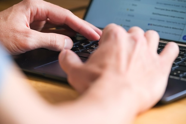 Mann tippt auf der Tastatur der Notebook-Nahaufnahme