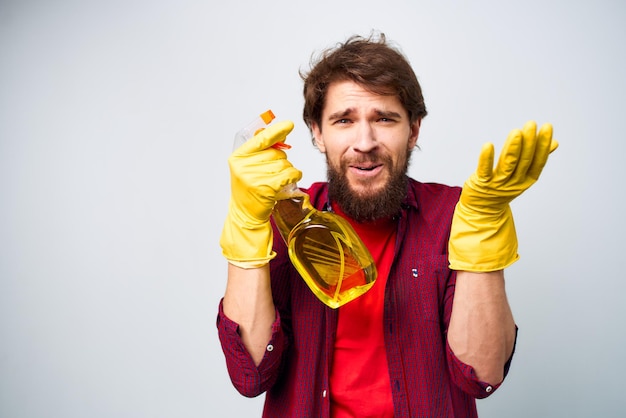 Mann trägt Gummihandschuhe, Reinigungsmittel, Hausaufgaben-Lebensstil