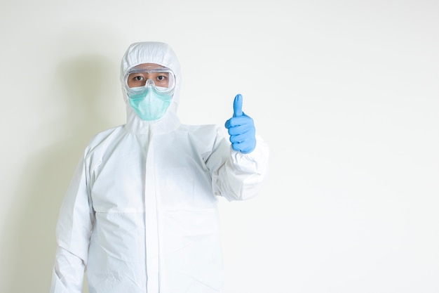 Mann tragen Hazmat Anzug schützen ansteckende Krankheit covid-19 Daumen hoch isoliert auf weißem Hintergrund