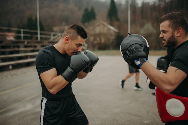 Mann trainiert Kickbox mit seinem professionellen Trainer