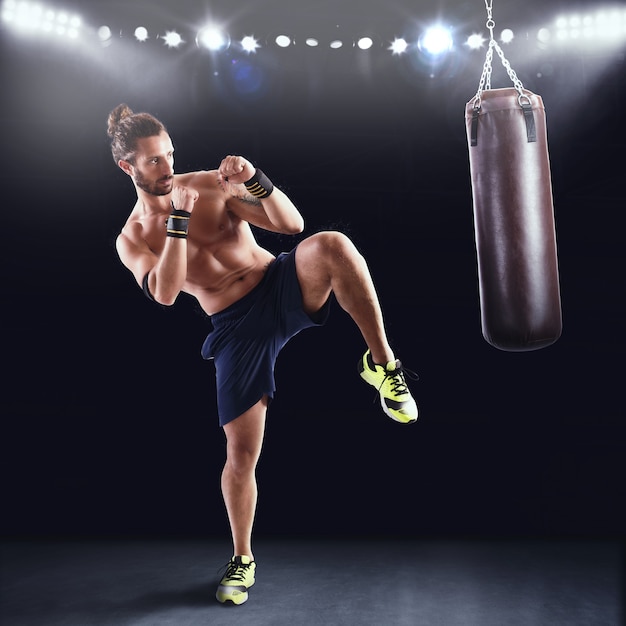 Mann trainiert mit dem Boxsack im Fitnessstudio