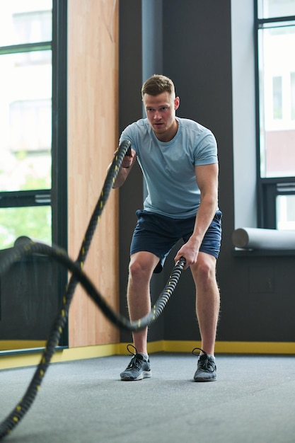 Mann trainiert mit Seil im Fitnessstudio