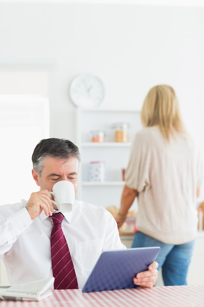 Mann trinkt Kaffee und mit Tablet-PC