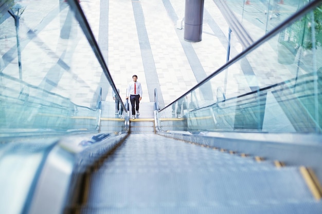 Mann tritt auf Rolltreppe