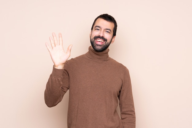 Mann über lokalisierter Begrüßung mit der Hand mit glücklichem Ausdruck