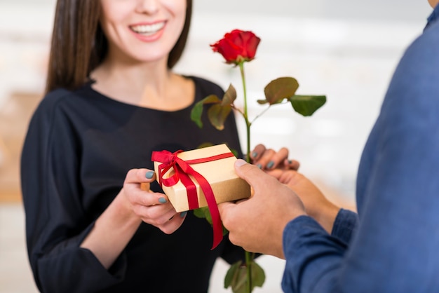 Foto mann überrascht seine smiley-freundin mit einem valentinstagsgeschenk