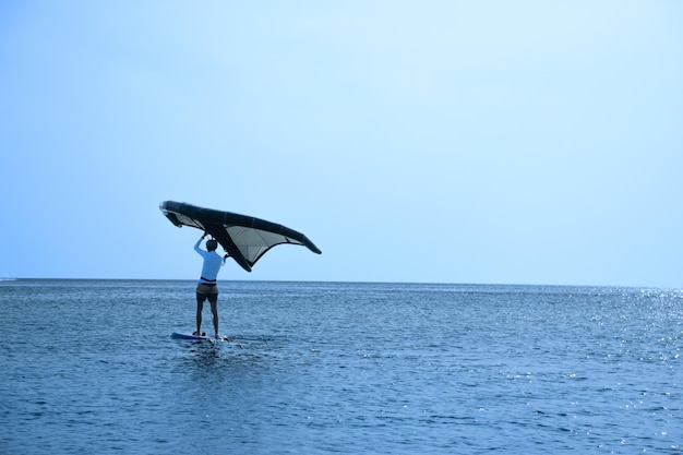 Mann übt Kitesurfen am Strand