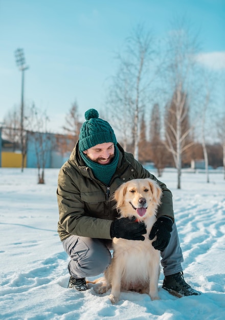 Foto mann umarmt sich mit einem hund golden retriever im freien