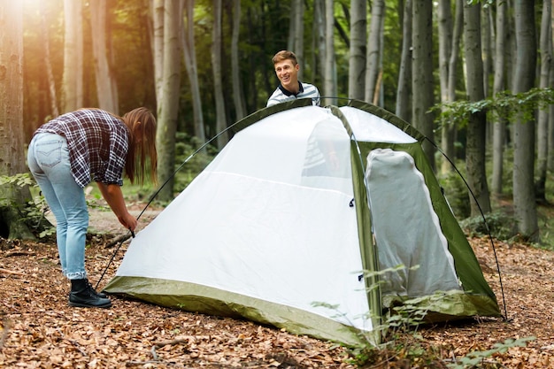 Mann und Frau Camper installieren Zelt im Park