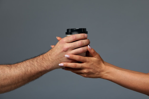 Mann und Frau, die eine Papierkaffeetasse halten