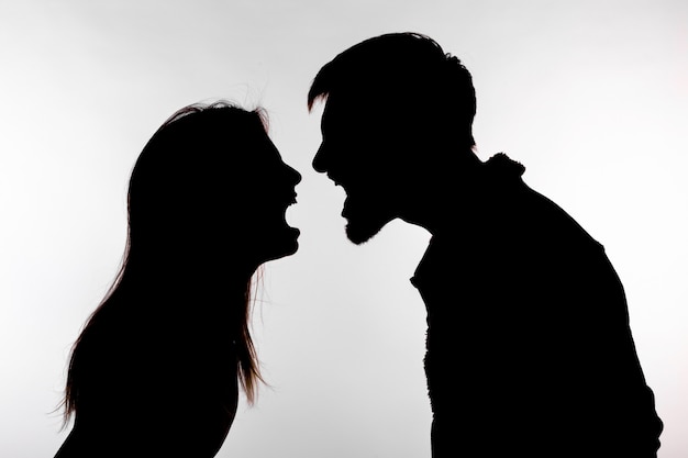 Mann und Frau, die häusliche Gewalt in der Studio-Silhouette ausdrücken