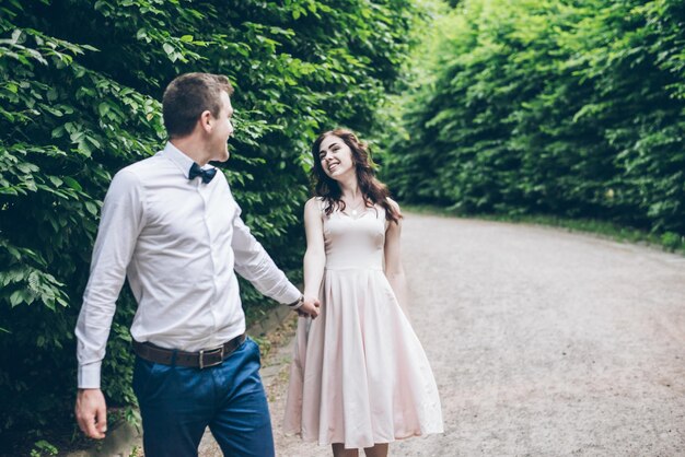Mann und Frau, die im eleganten Kleid im Park spazieren gehen