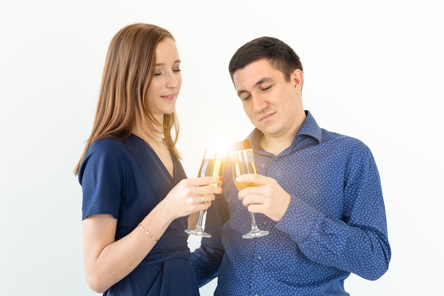 Mann und Frau, die Weihnachts- oder Silvesterparty mit Gläsern Champagner auf weißem Hintergrund feiern.