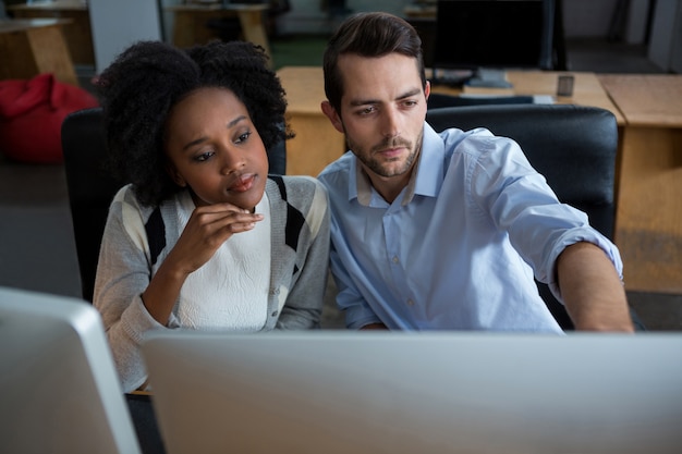 Mann und Frau diskutieren über Desktop-PC