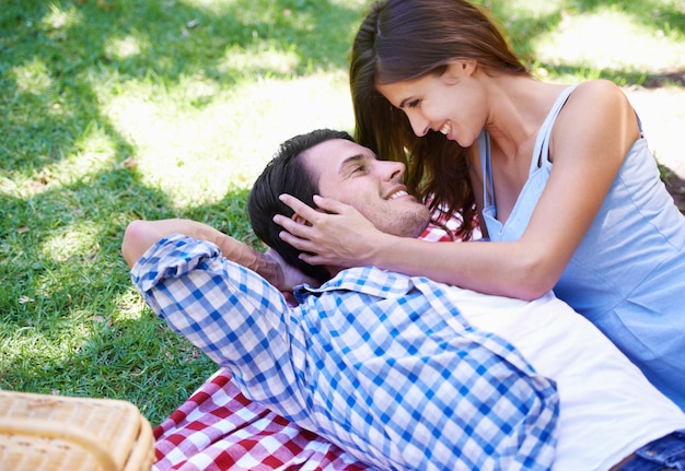 Mann und Frau entspannen sich im Park für ein Picknick im Urlaub für Sommer Bindung glücklich oder im Freien Paar lächeln und umarmen sich auf der Decke auf dem Gras für Valentinstag oder Dating Verbindung oder Ruhe Liebe oder Wochenende
