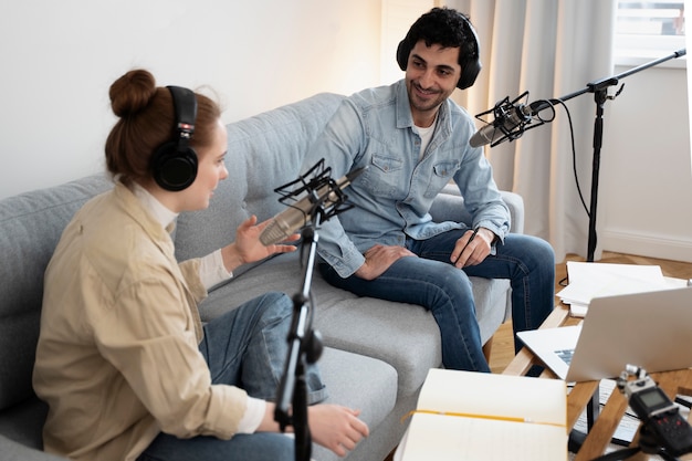 Mann und Frau führen gemeinsam einen Podcast im Studio durch