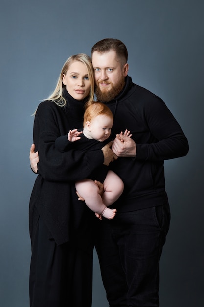 Mann und Frau halten ein Baby in den Armen.