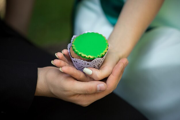 Mann und Frau halten grünen Cupcake. Saint Patrick Tag