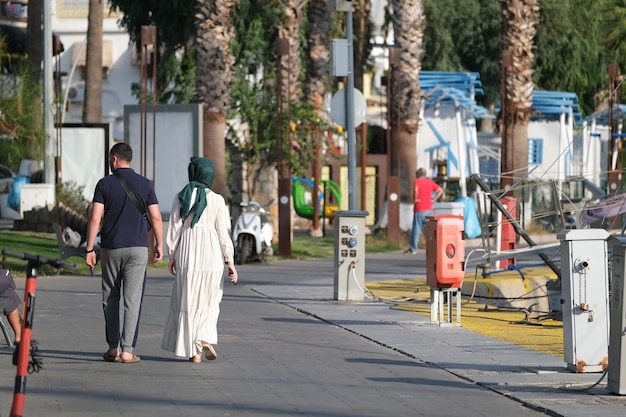 Mann und Frau im Hijab gehen die Straße entlang