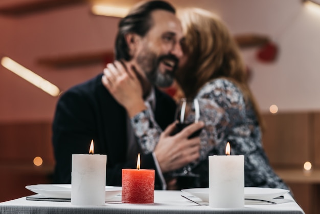 Foto mann und frau in einem restaurant umarmen an einem tisch weichzeichner