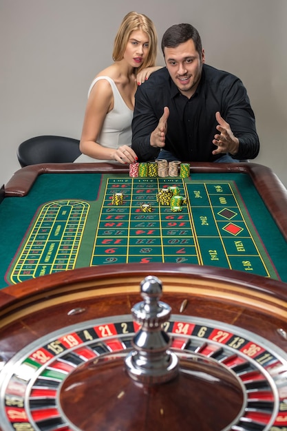 Mann und Frau jubeln am Roulette-Tisch im Casino