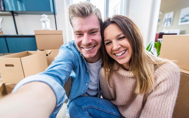 Mann und Frau machen ein Selfie beim Umzug in ein neues Zuhause