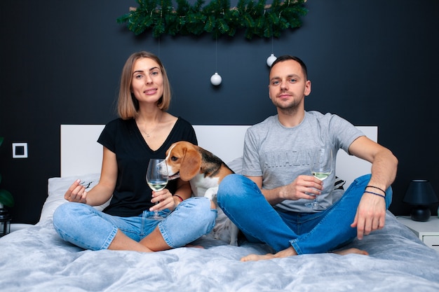 Mann und Frau mit Hund auf Bett