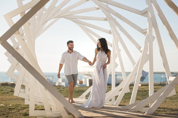 Mann und Frau posieren. Geometrische Holzkonstruktionen. Die Braut und der Bräutigam.