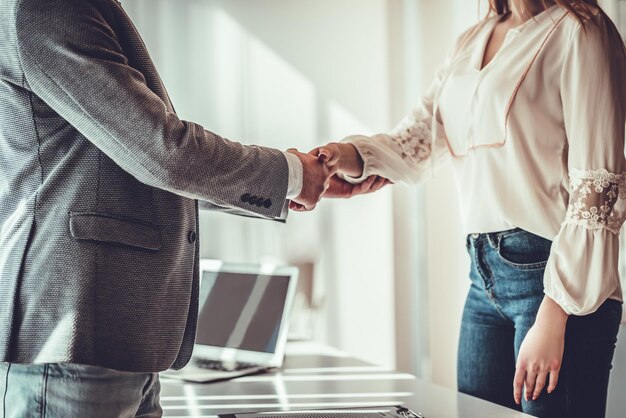 Mann und Frau schütteln sich im Büro die Hände Kollaborative Teamarbeit Nahaufnahme