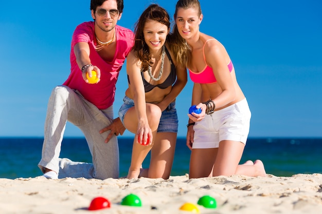 Mann und Frau spielen Boule am Strand